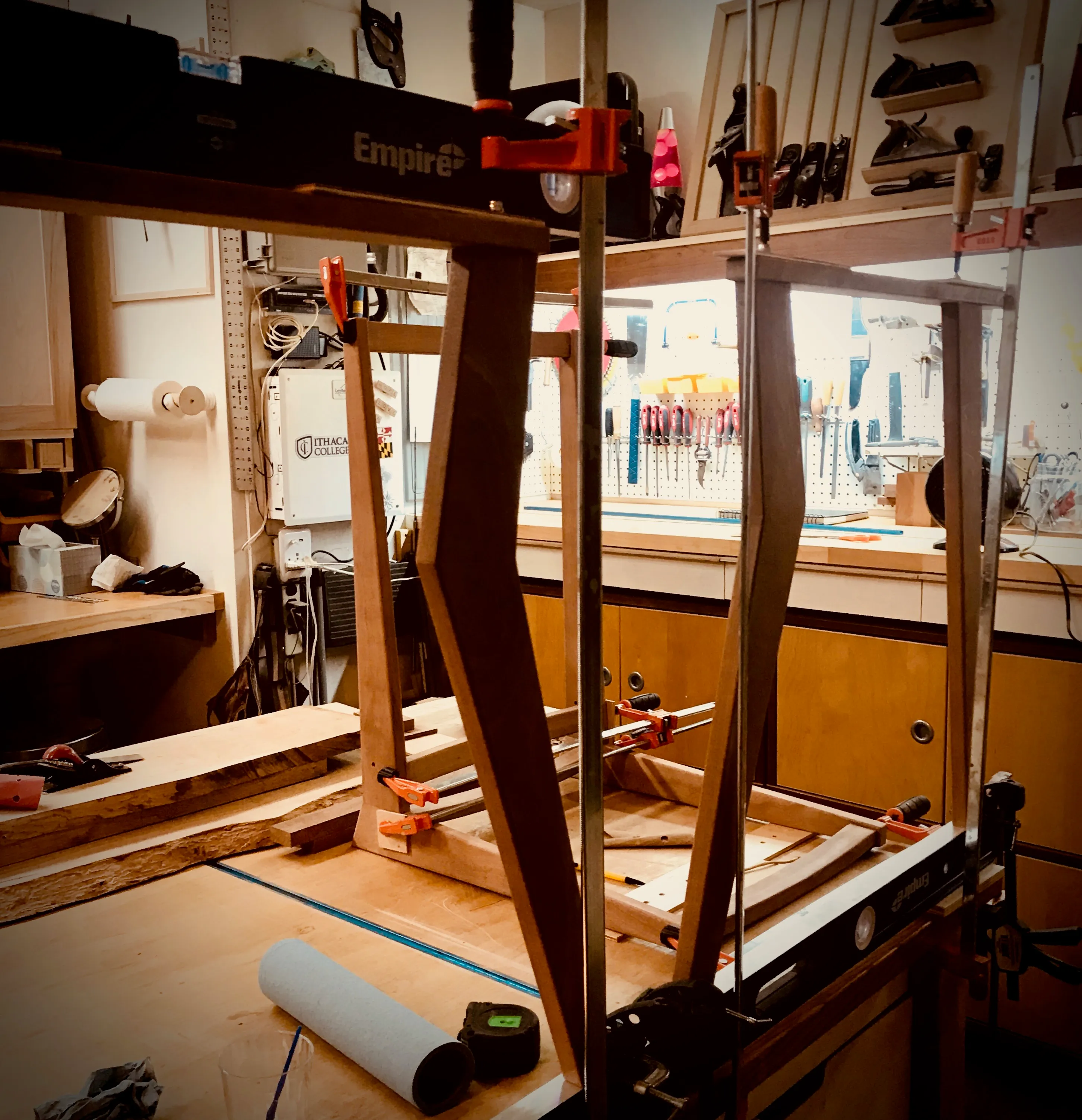 Marking dimension lines on a mahogany board for the chair's frame