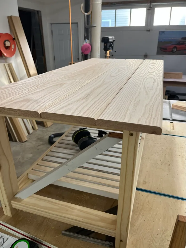 Raw oak boards for the coffee table's apron and shelf, clamped in an unfinished frame on the garage workbench
