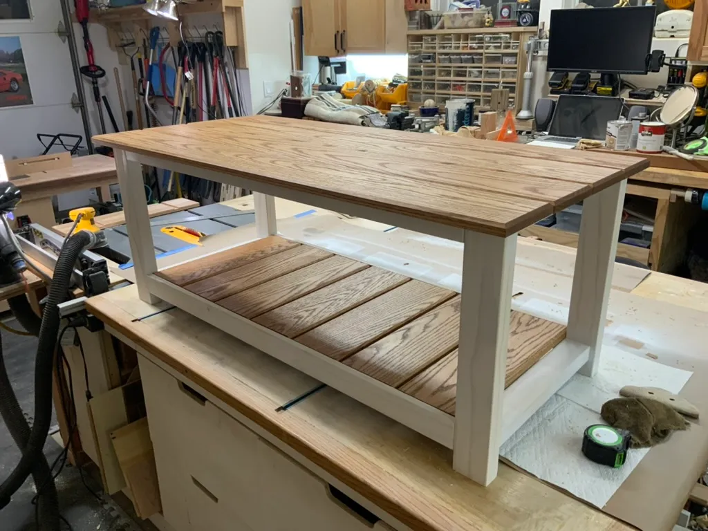 Finished white oak coffee table with slatted shelf, staged on the workbench in the shop before delivery