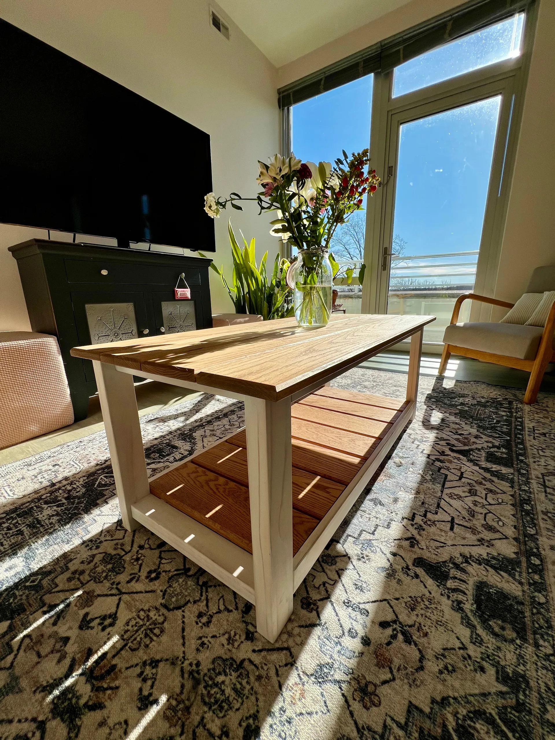 Side view of the white oak coffee table showing the off-white painted frame and legs