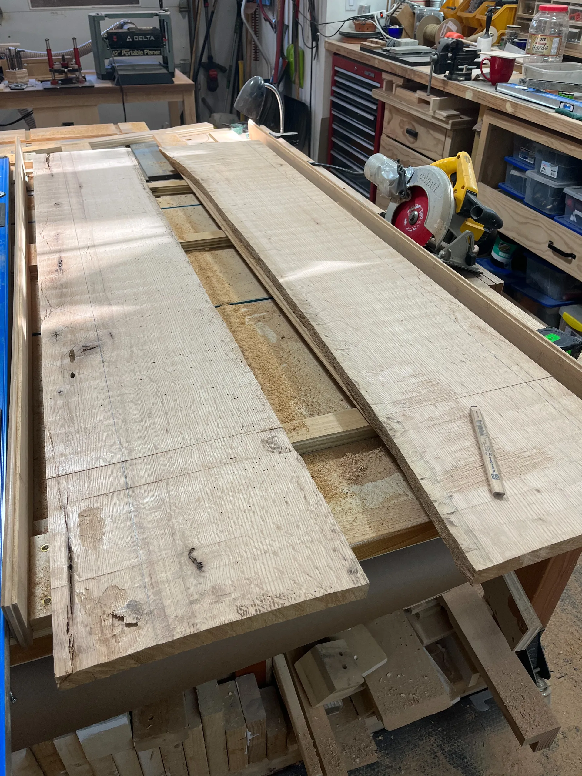 Rough white oak boards being milled and ripped on the workbench for the turtle table