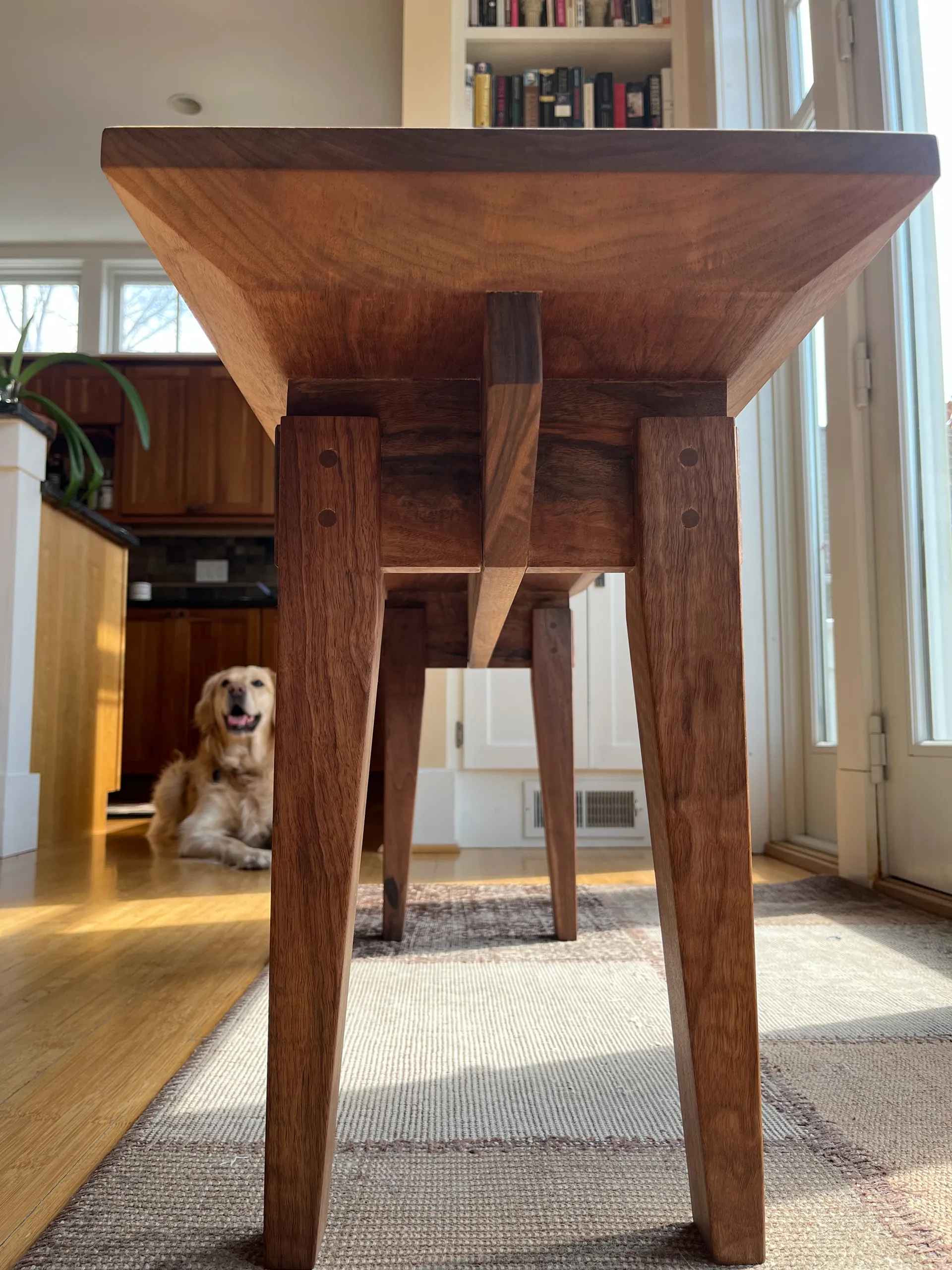 Side view of the walnut entryway bench showing its tapered legs