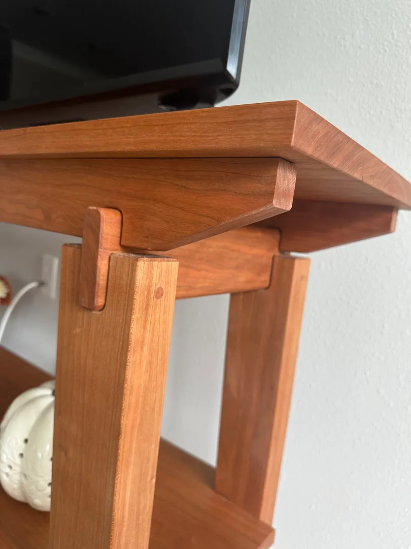 Side view of the cherry end table showing its square tapered legs