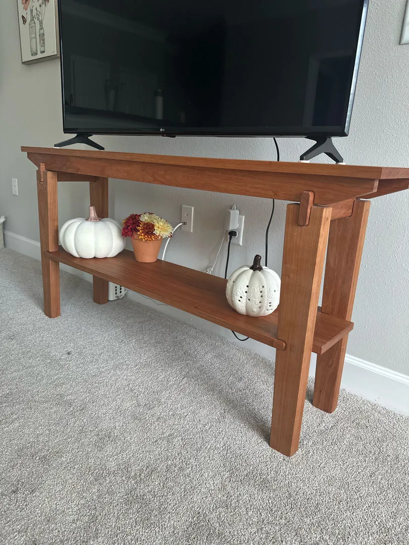 Cherry end table shown from a front angle with its lower shelf